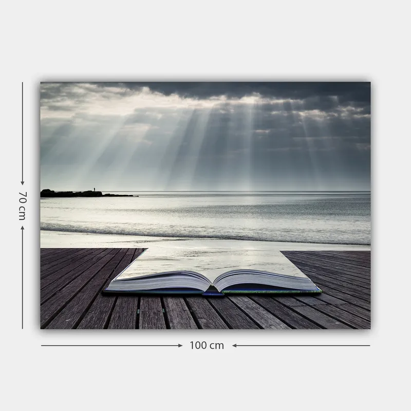 Canvastavla 70x100 cm - Öppen bok som ligger på en träbrygga vid havet, omgiven av mjuka ljusstrålar från en molnig himmel - Grå / Blå / Vit - Inredning - Tavlor & konst - Canvastavlor