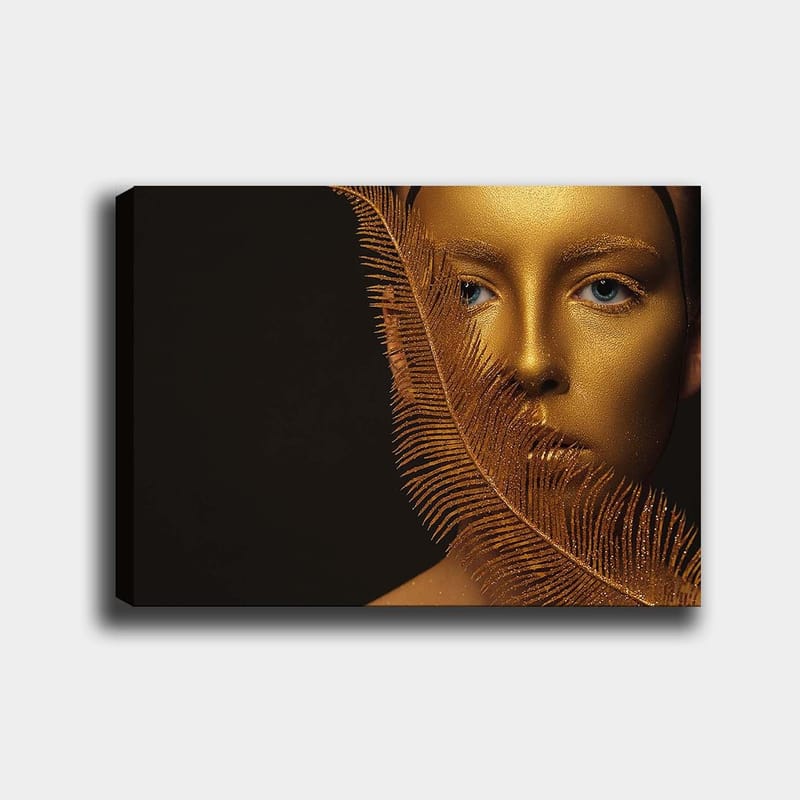 Canvastavla 70x100 cm - Ansiktsporträtt med en gyllene yta och blå ögon, omgiven av en dekorativ fjäderliknande struktur - Guld / Blå - Inredning - Tavlor & konst - Canvastavlor