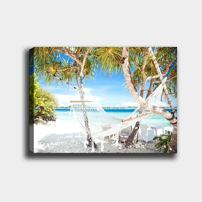 Canvastavla 70x100 cm - Avkopplande hängmatta mellan palmer vid en strand med turkost vatten och klarblå himmel, Vit / Blå / Grön