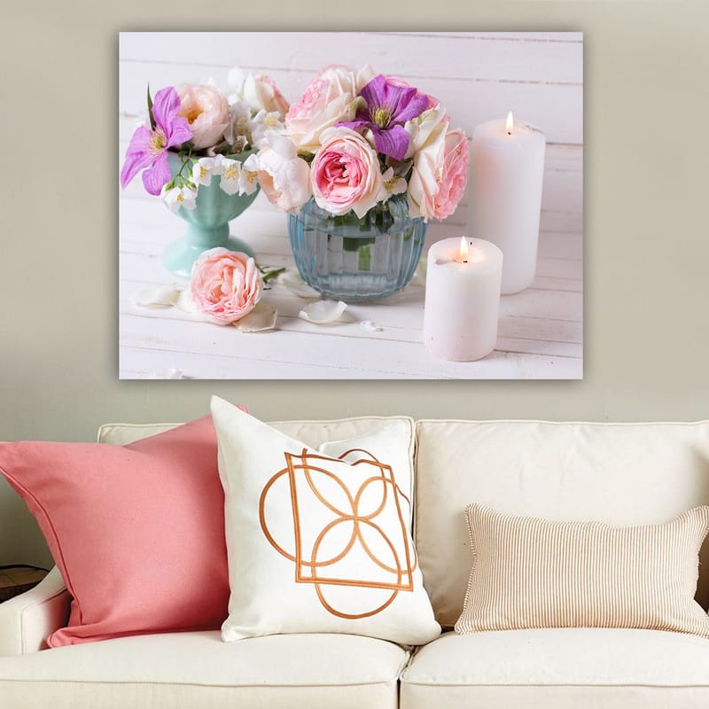 Canvastavla 70x100 cm - Bukett med rosa och lila blommor i en glasvas, omgiven av vita ljus, Rosa / Lila / Grön