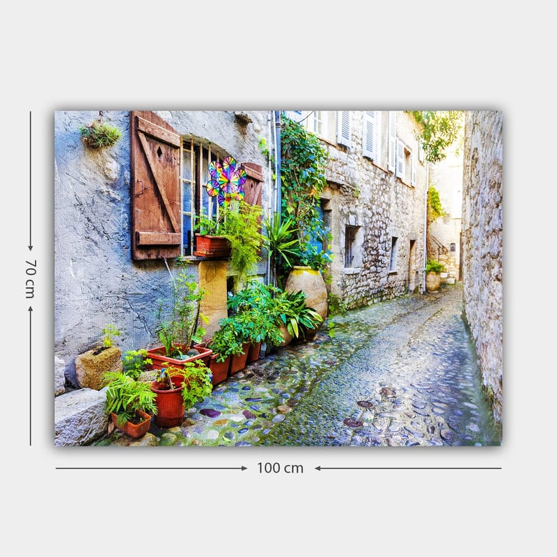 Canvastavla 70x100 cm - Charmig gränd med stenhus och blomsterkrukor som skapar en livlig atmosfär - Grön / Blå / Beige - Inredning - Tavlor & konst - Canvastavlor