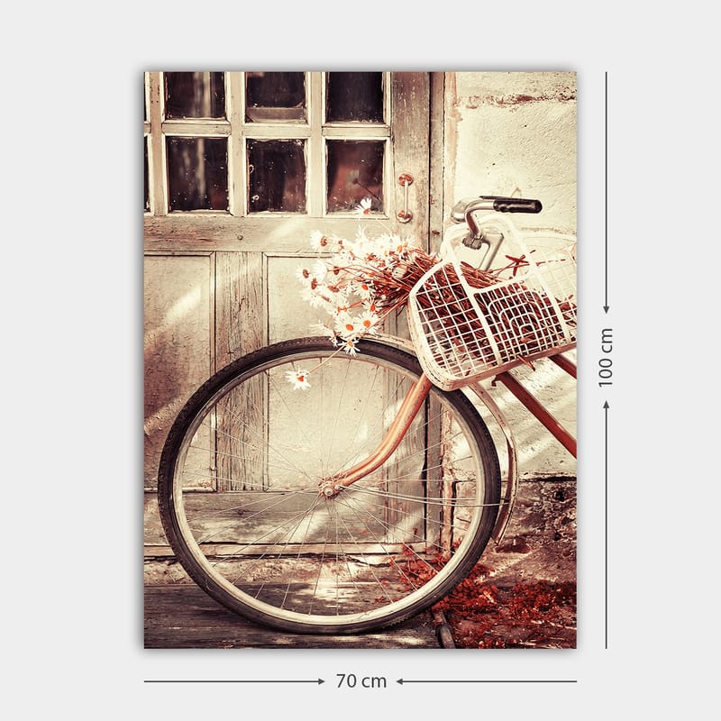 Canvastavla 70x100 cm - Cykel med en korg fylld med blommor framför en gammal dörr - Grå / Brun / Vit - Inredning - Tavlor & konst - Canvastavlor