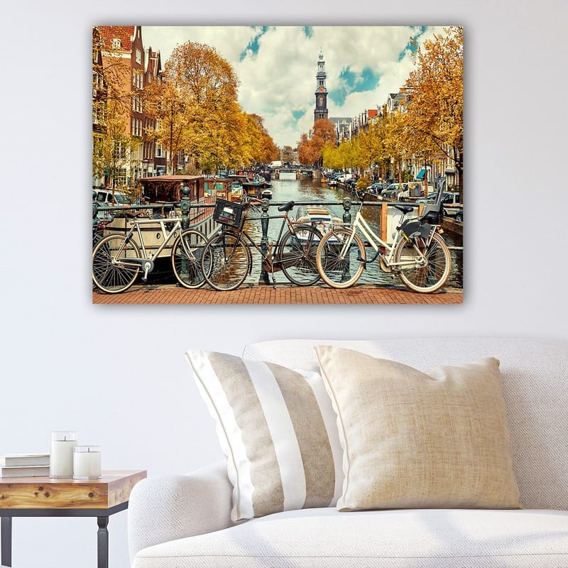 Canvastavla 70x100 cm - Cyklar vid en kanal i Amsterdam omgiven av höstfärger, Guldorange / Mörkblå / Vit