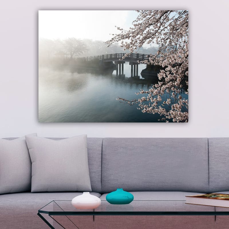 Canvastavla 70x100 cm - Dimmig scen med en bro som sträcker sig över en stilla sjö, omgiven av körsbärsträd i blom - Ljusrosa / Blå / Grå - Inredning - Tavlor & konst - Canvastavlor
