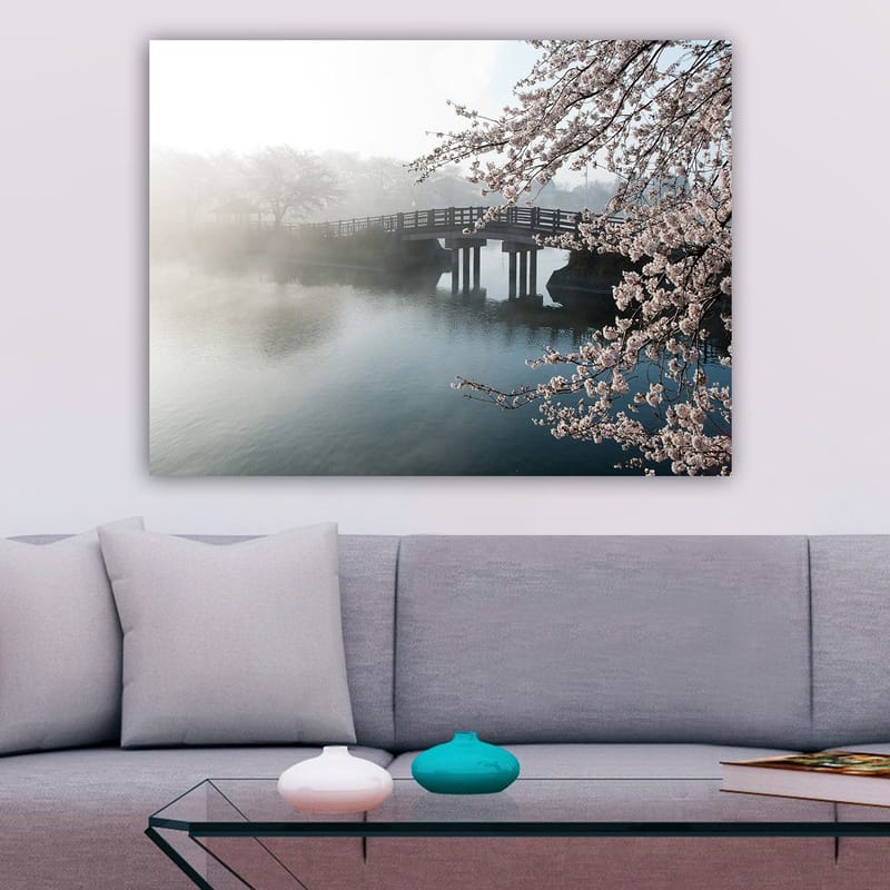 Canvastavla 70x100 cm - Dimmig scen med en bro som sträcker sig över en stilla sjö, omgiven av körsbärsträd i blom - Ljusrosa / Blå / Grå - Inredning - Tavlor & konst - Canvastavlor