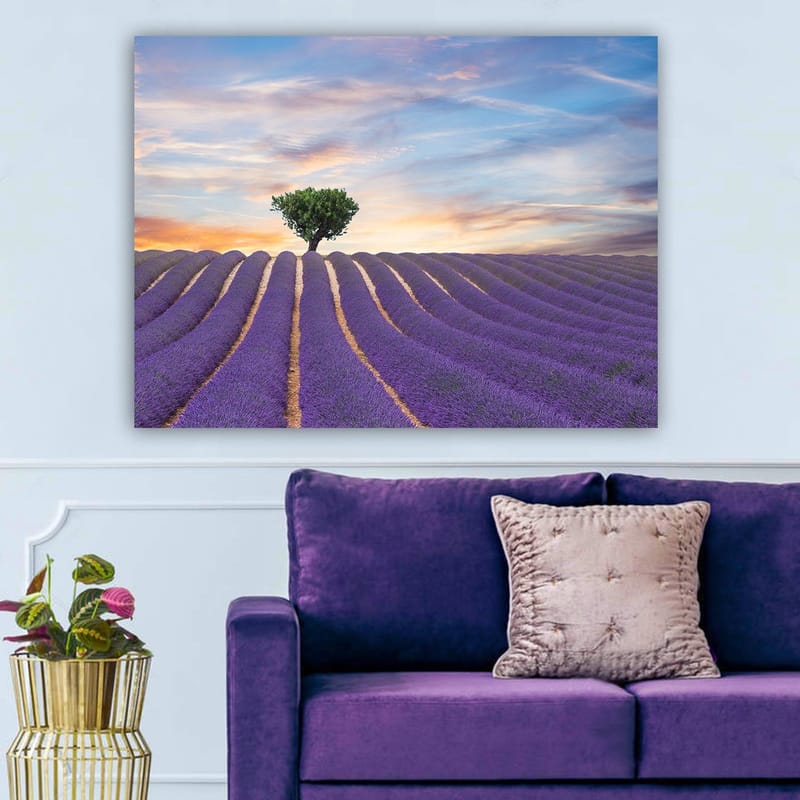 Canvastavla 70x100 cm - Ensam trädkrona står stolt över ett fält av lavendel i mjuka, vågiga rader under en färgsprakande himmel - Lila / Grön / Gul - Inredning - Tavlor & konst - Canvastavlor