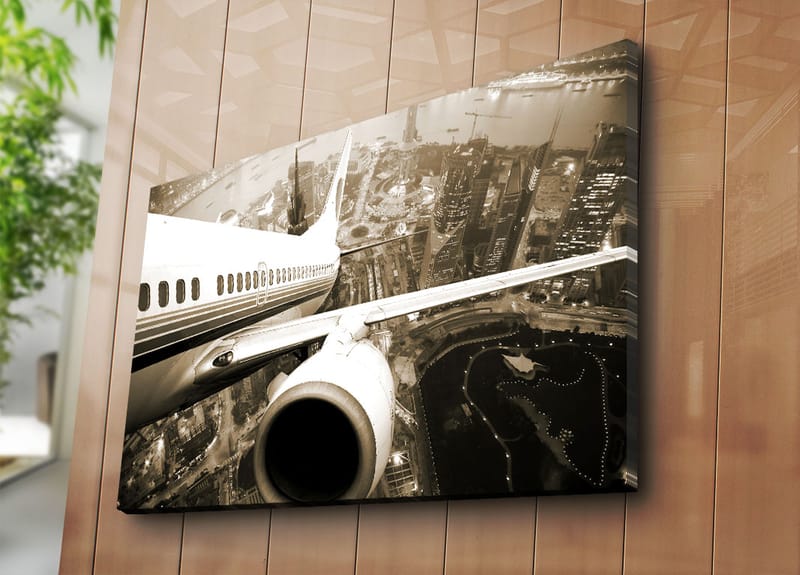 Canvastavla 70x100 cm - Ett flygplan som svävar över en stad i skymningsljus - Svart / Vit / Grå - Inredning - Tavlor & konst - Canvastavlor