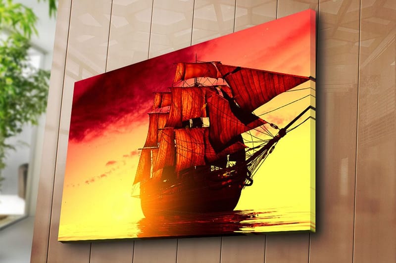 Canvastavla 70x100 cm - Ett majestätiskt segelfartyg med röda segel som navigerar genom en gyllene solnedgång - Röd / Orange / Gul - Inredning - Tavlor & konst - Canvastavlor