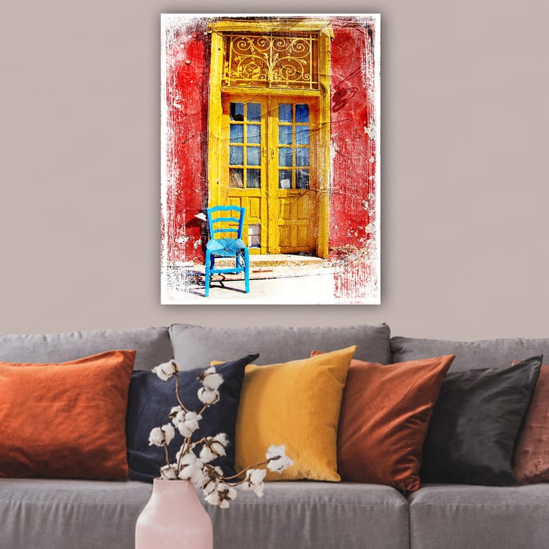 Canvastavla 70x100 cm - Färgglad dörr med en blå stol framför på en röd vägg - Gul / Röd / Blå - Inredning - Tavlor & konst - Canvastavlor