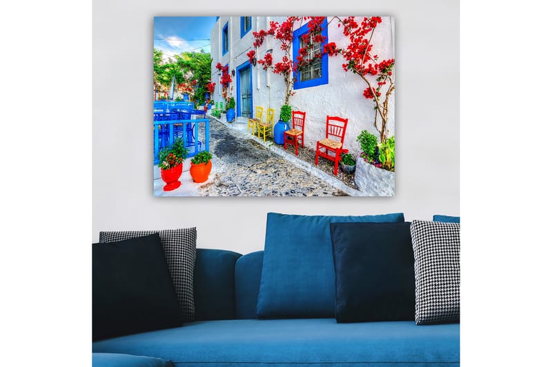 Canvastavla 70x100 cm - Färgglad gata med blommor och stolar i olika färger som skapar en livlig atmosfär - Blå / Röd / Grön - Inredning - Tavlor & konst - Canvastavlor