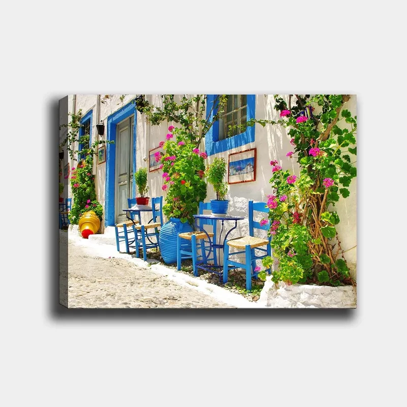 Canvastavla 70x100 cm - Färgglad och livlig gata med blå stolar och blomkrukor i en medelhavsmiljö, Blå / Grön / Rosa