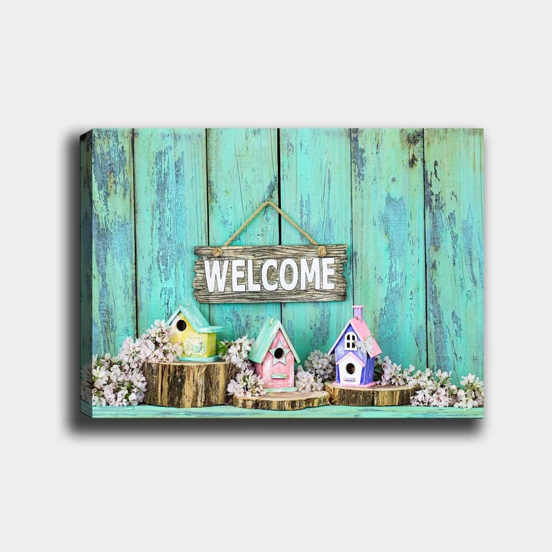Canvastavla 70x100 cm - Färgglada fågelholkar i en välkomnande miljö med en träskylt, Turkos / Rosa / Gul