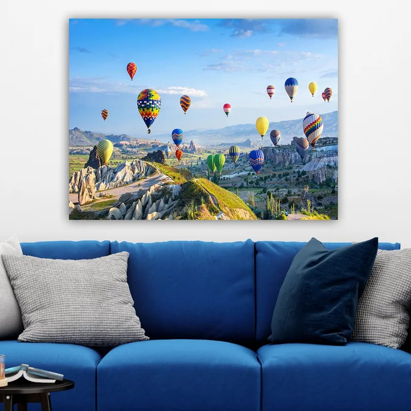 Canvastavla 70x100 cm - Färgglada varmluftsballonger sväva över en vacker landskapsscen i Cappadocia - Grön / Blå / Gul - Inredning - Tavlor & konst - Canvastavlor