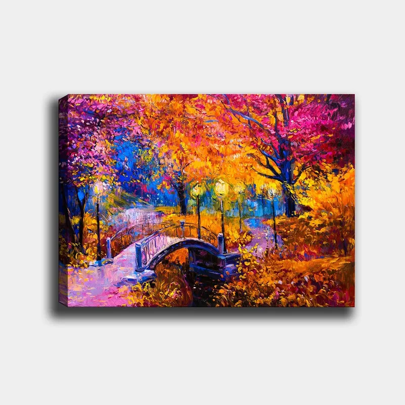 Canvastavla 70x100 cm - Färgsprakande höstscen med en bro som sträcker sig över en stilla vattenyta, omgiven av träd i varma höstfärger, Orange / Lila / Gult