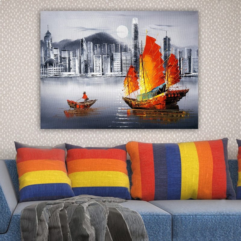 Canvastavla 70x100 cm - Färgstark segelbåt med röda segel på en spegelblanka vattenyta, omgiven av en modern stadsbild - Röd / Orange / Blå - Inredning - Tavlor & konst - Canvastavlor
