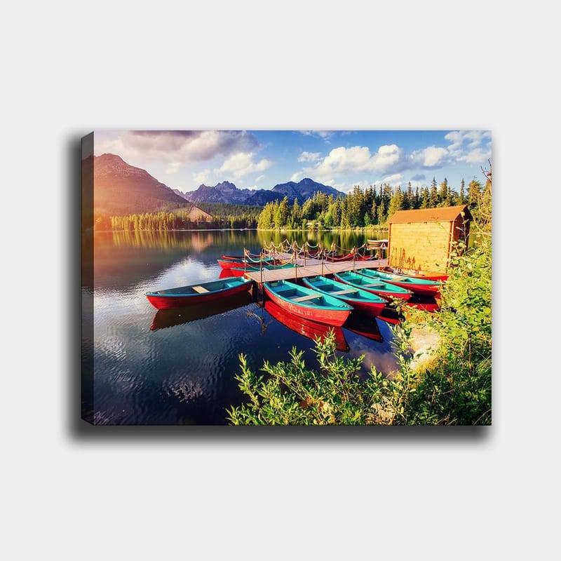 Canvastavla 70x100 cm - Flera färgglada båtar ligger vid en spegelblanka sjö omgiven av grönskande träd och berg - Röd / Turkos / Grön - Inredning - Tavlor & konst - Canvastavlor