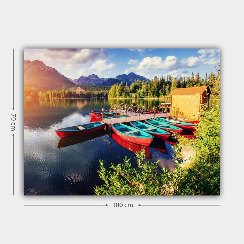 Canvastavla 70x100 cm - Flera färgglada båtar ligger vid en spegelblanka sjö omgiven av grönskande träd och berg - Röd / Turkos / Grön - Inredning - Tavlor & konst - Canvastavlor