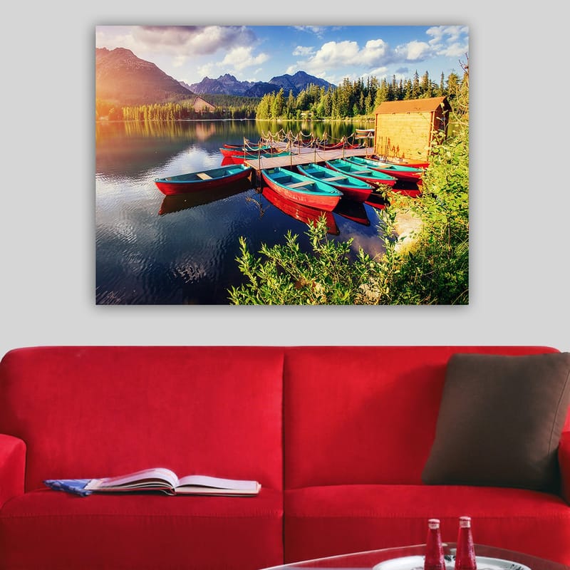 Canvastavla 70x100 cm - Flera färgglada båtar ligger vid en spegelblanka sjö omgiven av grönskande träd och berg - Röd / Turkos / Grön - Inredning - Tavlor & konst - Canvastavlor