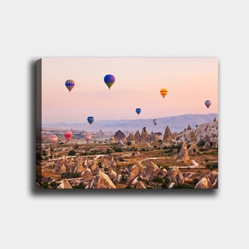 Canvastavla 70x100 cm - Flera färgglada luftballonger sväva över en dramatisk landskap med unika klippformationer - Blå / Röd / Orange - Inredning - Tavlor & konst - Canvastavlor