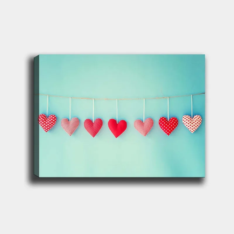 Canvastavla 70x100 cm - Hängande hjärtan i olika mönster och nyanser av röd färg, Röd / Ljusblå / Vit