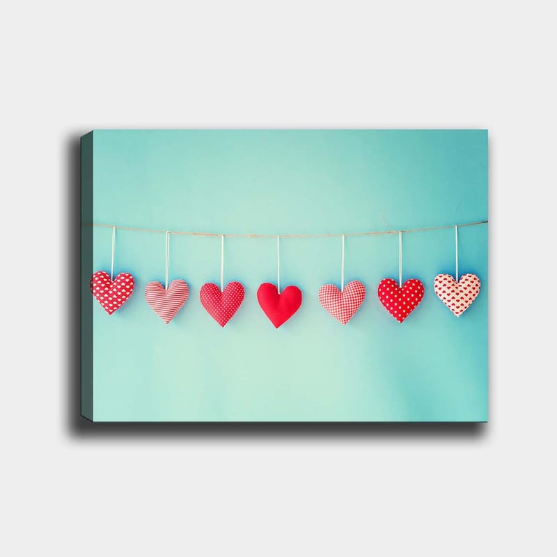 Canvastavla 70x100 cm - Hängande hjärtan i olika mönster och nyanser av röd färg, Röd / Ljusblå / Vit