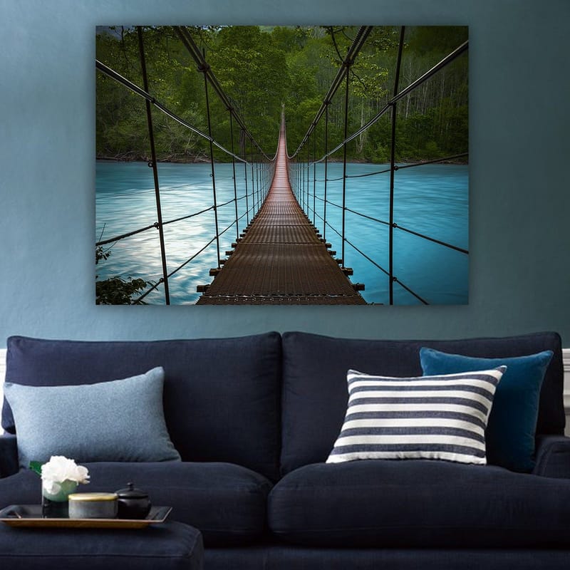 Canvastavla 70x100 cm - Hängbro som sträcker sig över en stilla, blå flod omgiven av grönskande träd - Mörkbrun / Turkos / Grön - Inredning - Tavlor & konst - Canvastavlor