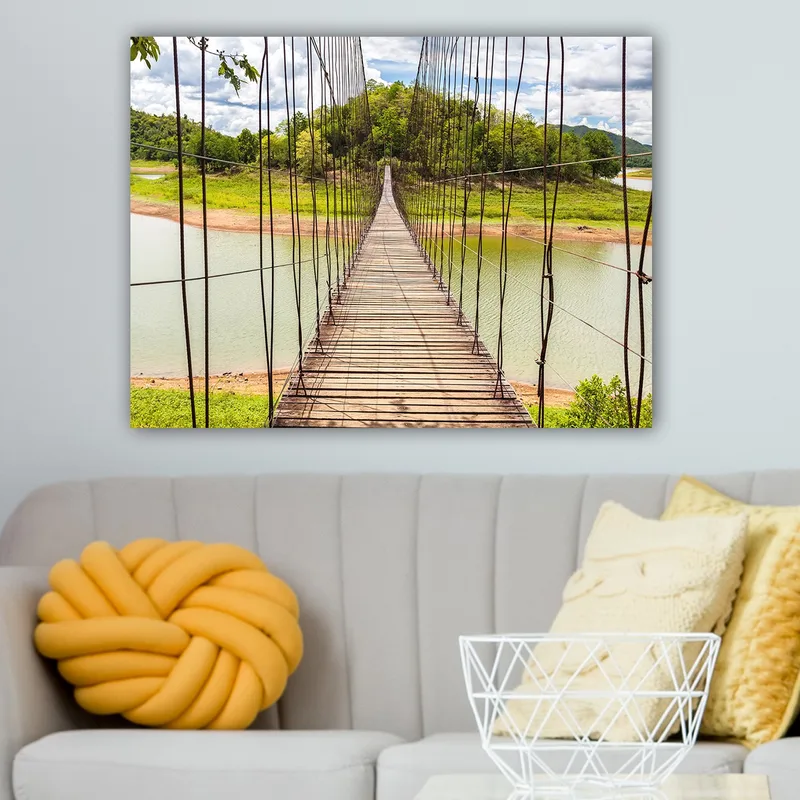 Canvastavla 70x100 cm - Hängbro som sträcker sig över en stilla sjö, omgiven av grönskande landskap - Grön / Brun / Blå - Inredning - Tavlor & konst - Canvastavlor