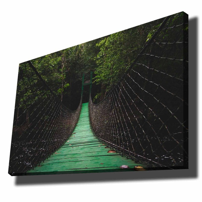 Canvastavla 70x100 cm - Hängbro som sträcker sig genom en grönskande skog, Grön / Svart
