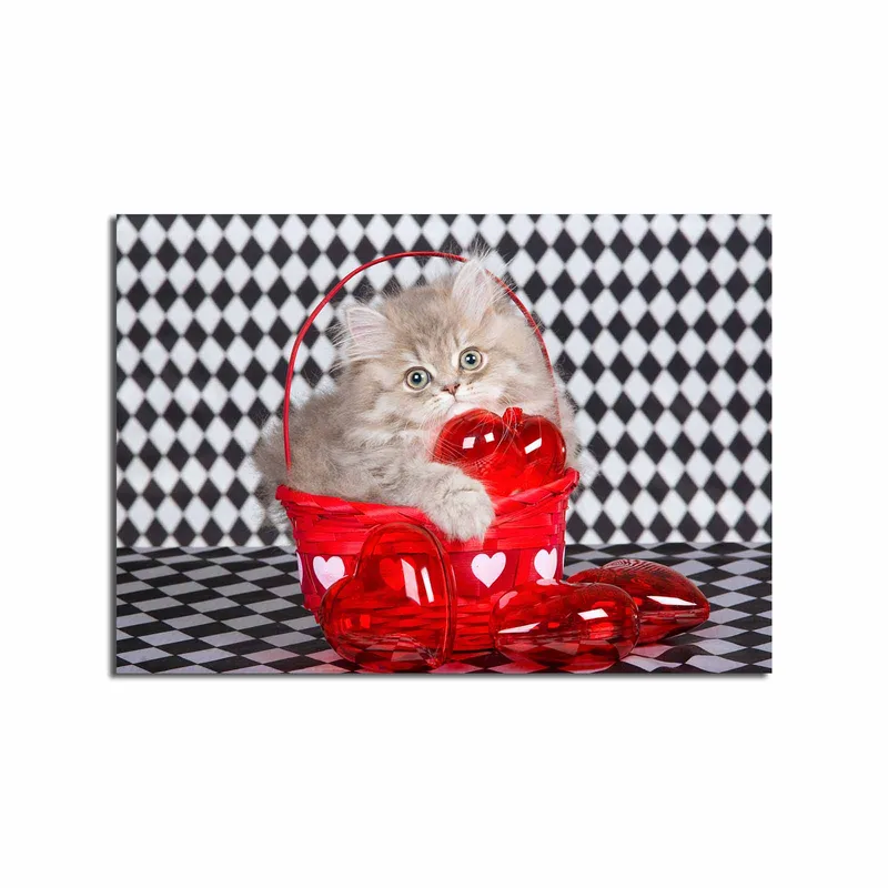 Canvastavla 70x100 cm - Kattunge som sitter i en röd korg fylld med hjärtformade dekorationer - Röd / Grå - Inredning - Tavlor & konst - Canvastavlor