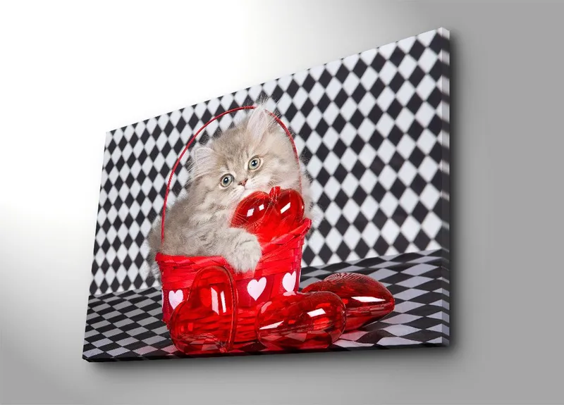 Canvastavla 70x100 cm - Kattunge som sitter i en röd korg fylld med hjärtformade dekorationer - Röd / Grå - Inredning - Tavlor & konst - Canvastavlor