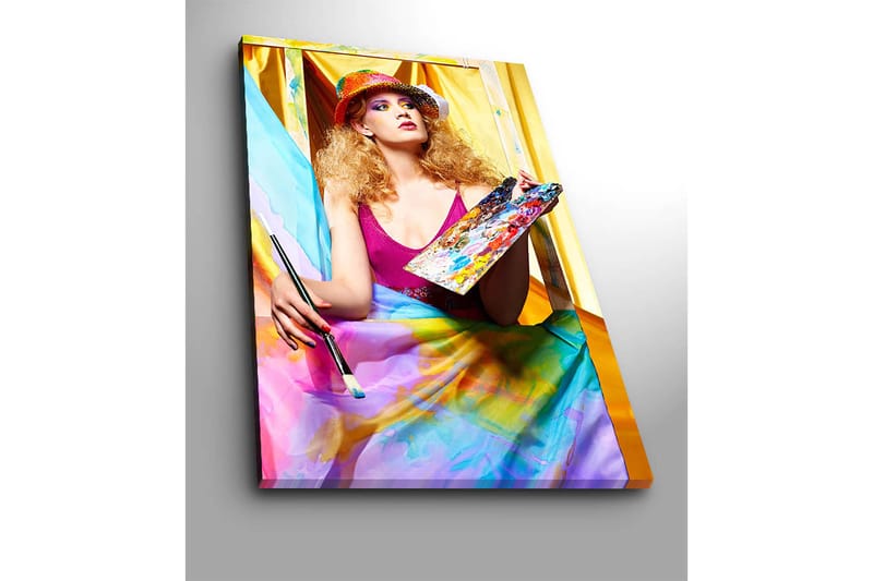 Canvastavla 70x100 cm - Kreativ kvinna som målar med en palett i handen, omgiven av färgglada tyger - Rosa / Blå / Gul - Inredning - Tavlor & konst - Canvastavlor
