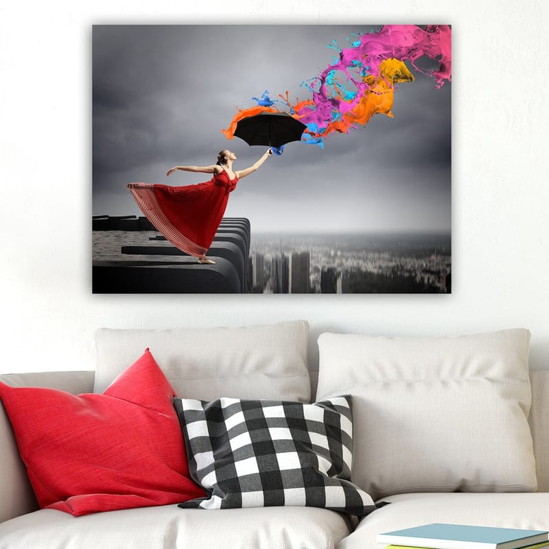 Canvastavla 70x100 cm - Kvinna i röd klänning står på en kant och håller ett paraply, medan färgglada färgstrålar sprutar ut från det - Röd / Svart / Orange - Inredning - Tavlor & konst - Canvastavlor