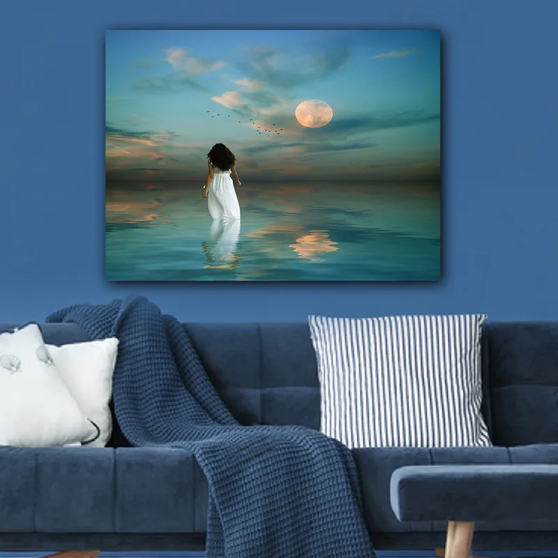 Canvastavla 70x100 cm - Kvinna i vit klänning går genom ett spegelblanka hav under en stjärnklar himmel med en stor måne - Blå / Vit / Grå - Inredning - Tavlor & konst - Canvastavlor
