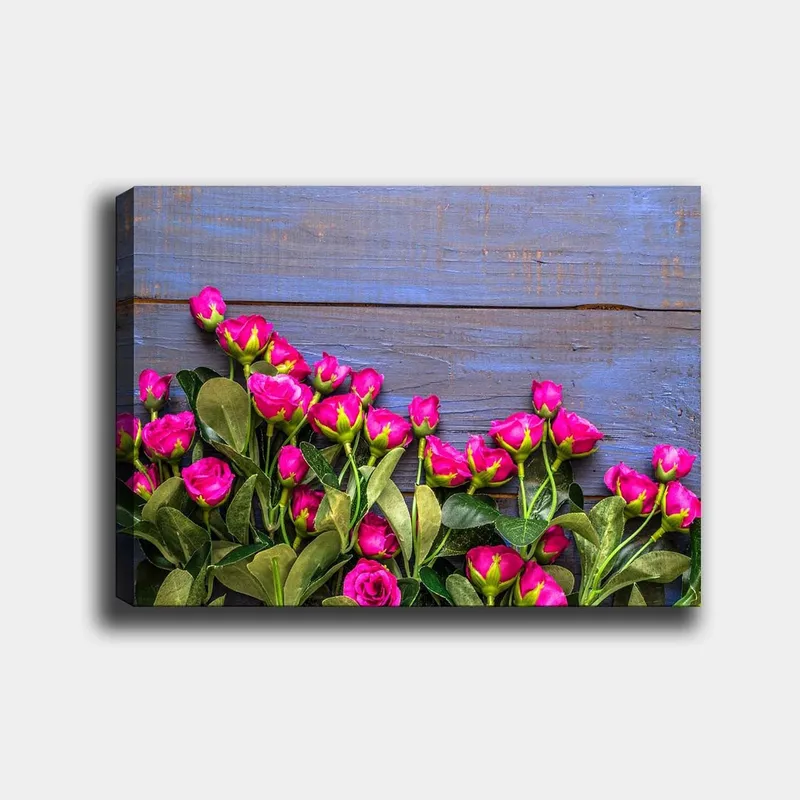 Canvastavla 70x100 cm - Livfull samling av rosa rosor mot en blå träbakgrund, Rosa / Grön / Blå