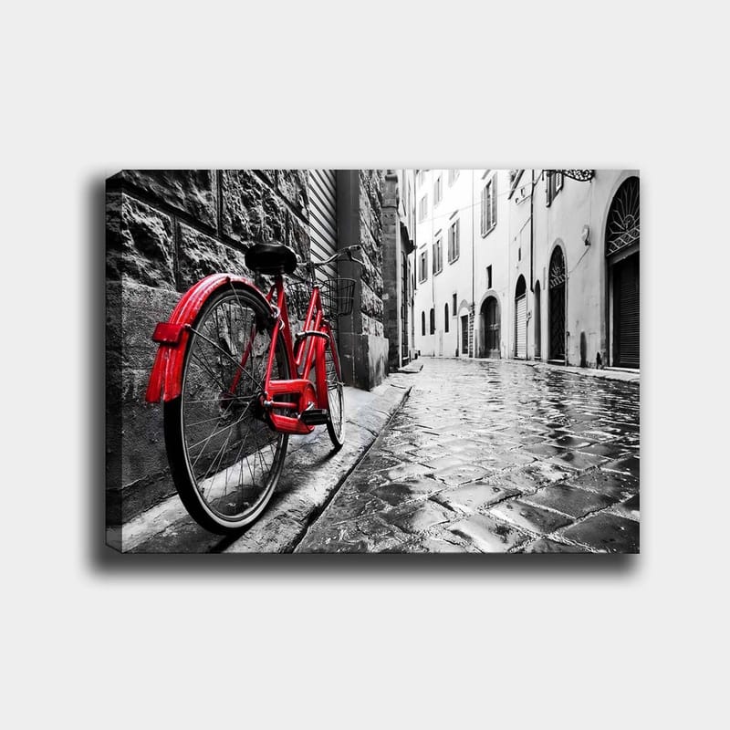 Canvastavla 70x100 cm - Röd cykel står lutad mot en vägg i en svartvit stadsmiljö, Röd / Svart / Grå