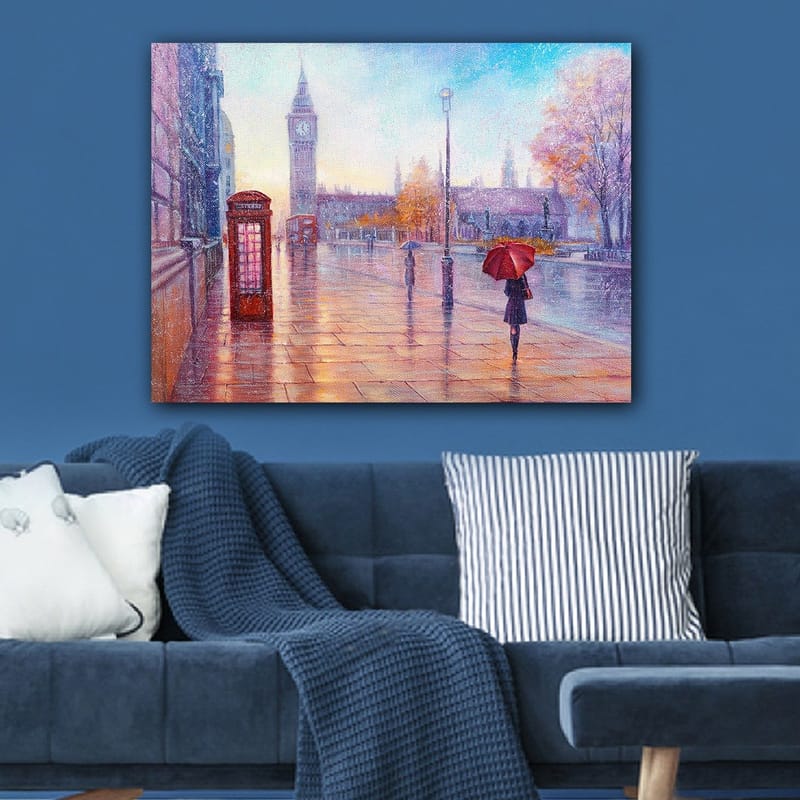 Canvastavla 70x100 cm - Regnig stadsbild med en röd telefonkiosk och en person med röd paraply som promenerar längs en blöt gata - Röd / Blå / Orange - Inredning - Tavlor & konst - Canvastavlor
