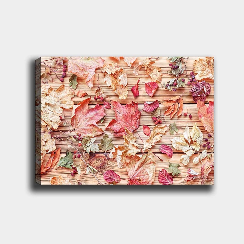 Canvastavla 70x100 cm - Samling av höstlöv i olika färger som ligger på en träyta - Röd / Gul / Grön - Inredning - Tavlor & konst - Canvastavlor