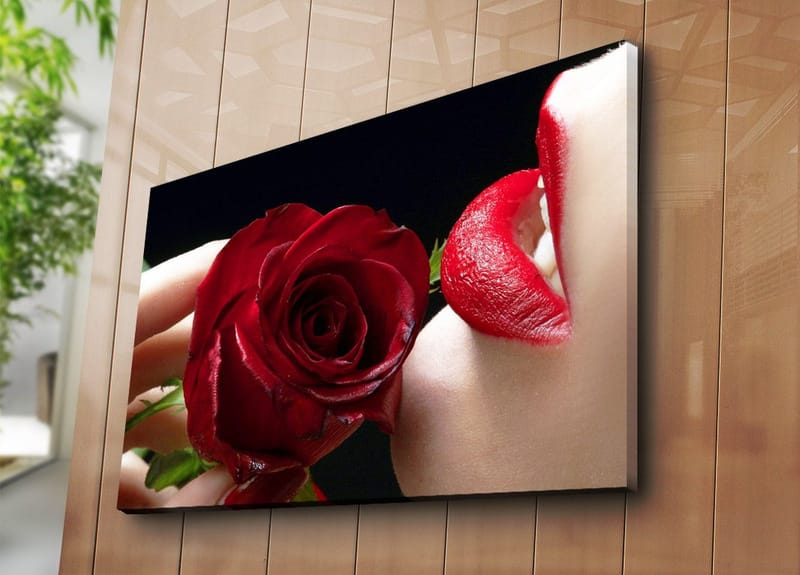 Canvastavla 70x100 cm - Sensuell närbild av en ros som hålls nära en läpp med röd läppstift - Röd / Grön - Inredning - Tavlor & konst - Canvastavlor