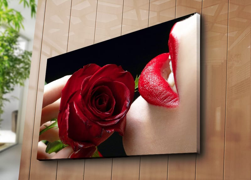 Canvastavla 70x100 cm - Sensuell närbild av en ros som hålls nära en läpp med röd läppstift - Röd / Grön - Inredning - Tavlor & konst - Canvastavlor