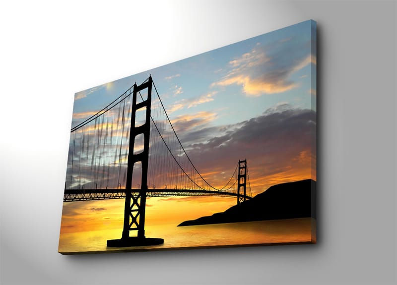 Canvastavla 70x100 cm - Silhuett av en bro mot en färgsprakande solnedgång - Orange / Svart / Blå - Inredning - Tavlor & konst - Canvastavlor