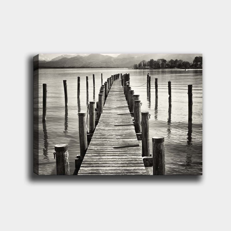 Canvastavla 70x100 cm - Stilla brygga som sträcker sig ut över vattnet, omgiven av pelare som reflekteras i ytan, Svart / Vitt / Grått
