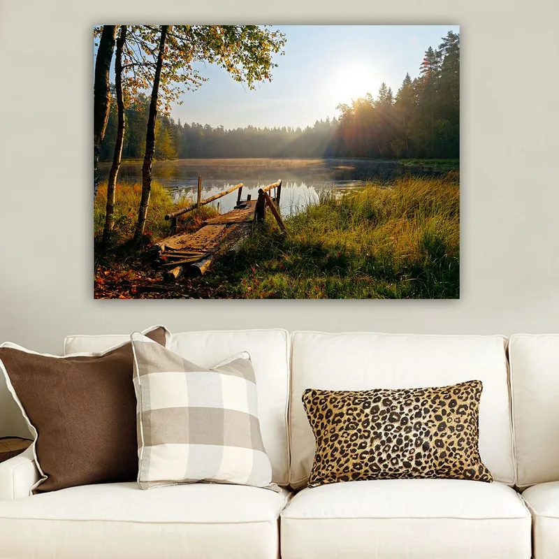 Canvastavla 70x100 cm - Stilla sjö med en träbro omgiven av grönskande träd och morgonsolens strålar - Grön / Brun / Gul - Inredning - Tavlor & konst - Canvastavlor