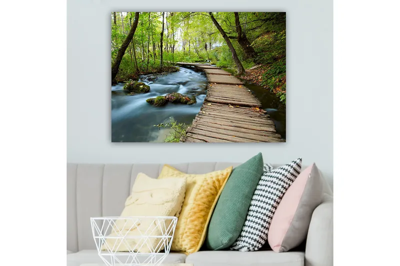 Canvastavla 70x100 cm - Stilla skogsstig som slingrar sig över en porlande bäck omgiven av grönskande träd och växtlighet - Grön / Brun / Blå - Inredning - Tavlor & konst - Canvastavlor