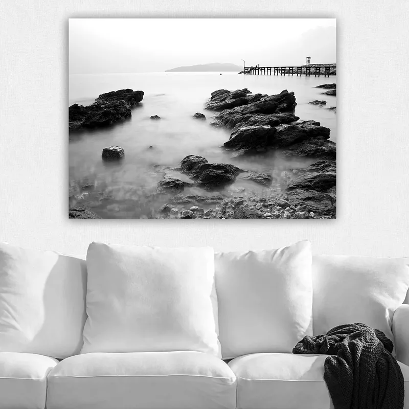 Canvastavla 70x100 cm - Stillsam kustlandskap med klippor och en brygga i fjärran - Svart / Vitt / Grått - Inredning - Tavlor & konst - Canvastavlor