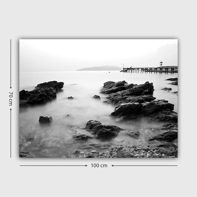 Canvastavla 70x100 cm - Stillsam kustlandskap med klippor och en brygga i fjärran - Svart / Vitt / Grått - Inredning - Tavlor & konst - Canvastavlor