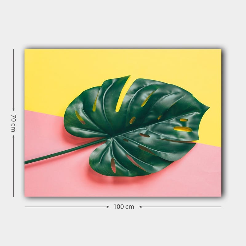 Canvastavla 70x100 cm - Stor, grön monstera-blad mot en färgglad bakgrund av gul och rosa - Grön / Gul / Rosa - Inredning - Tavlor & konst - Canvastavlor