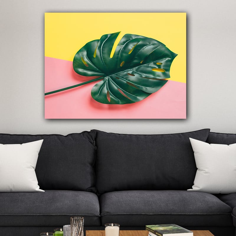 Canvastavla 70x100 cm - Stor, grön monstera-blad mot en färgglad bakgrund av gul och rosa - Grön / Gul / Rosa - Inredning - Tavlor & konst - Canvastavlor