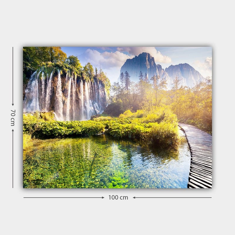 Canvastavla 70x100 cm - Storslagen vattenfallsscen omgiven av grönskande vegetation och majestätiska berg - Grön / Blå / Gul - Inredning - Tavlor & konst - Canvastavlor