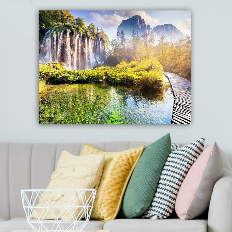 Canvastavla 70x100 cm - Storslagen vattenfallsscen omgiven av grönskande vegetation och majestätiska berg - Grön / Blå / Gul - Inredning - Tavlor & konst - Canvastavlor