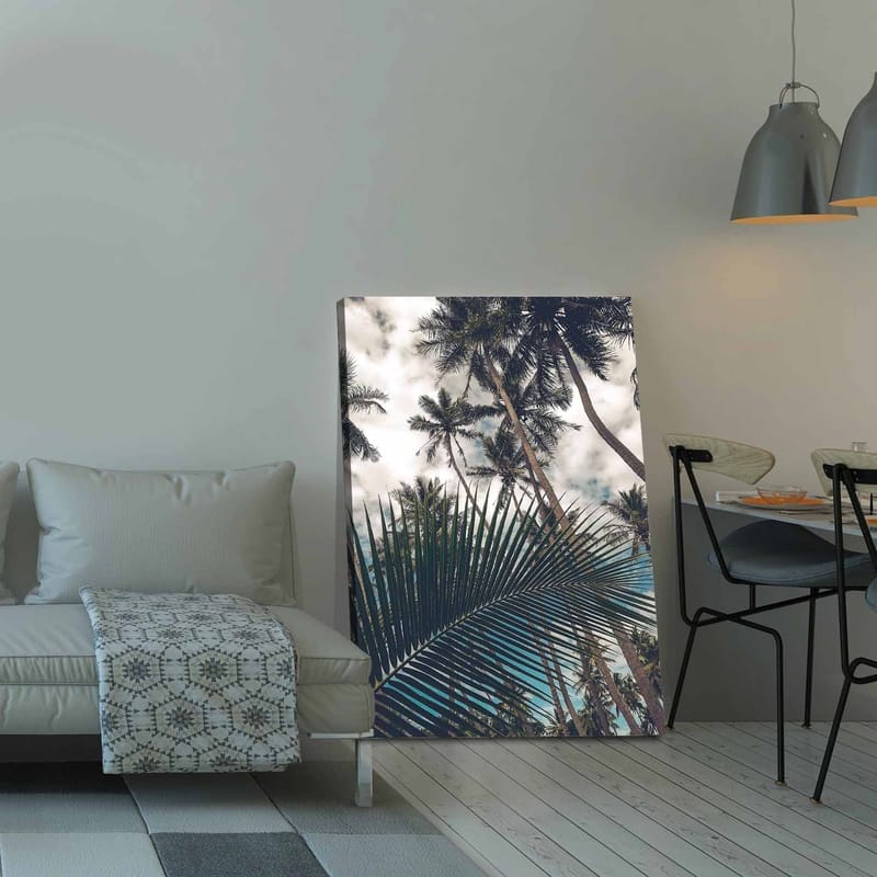 Canvastavla 70x100 cm - Tropisk palmlund med en stor palmblad i förgrunden - Mörkgrön / Ljusgrön / Blå - Inredning - Tavlor & konst - Canvastavlor